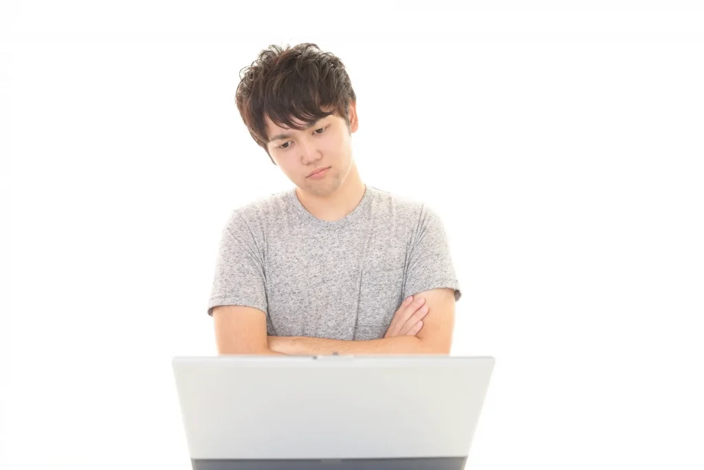 パソコンの前で悩む男性